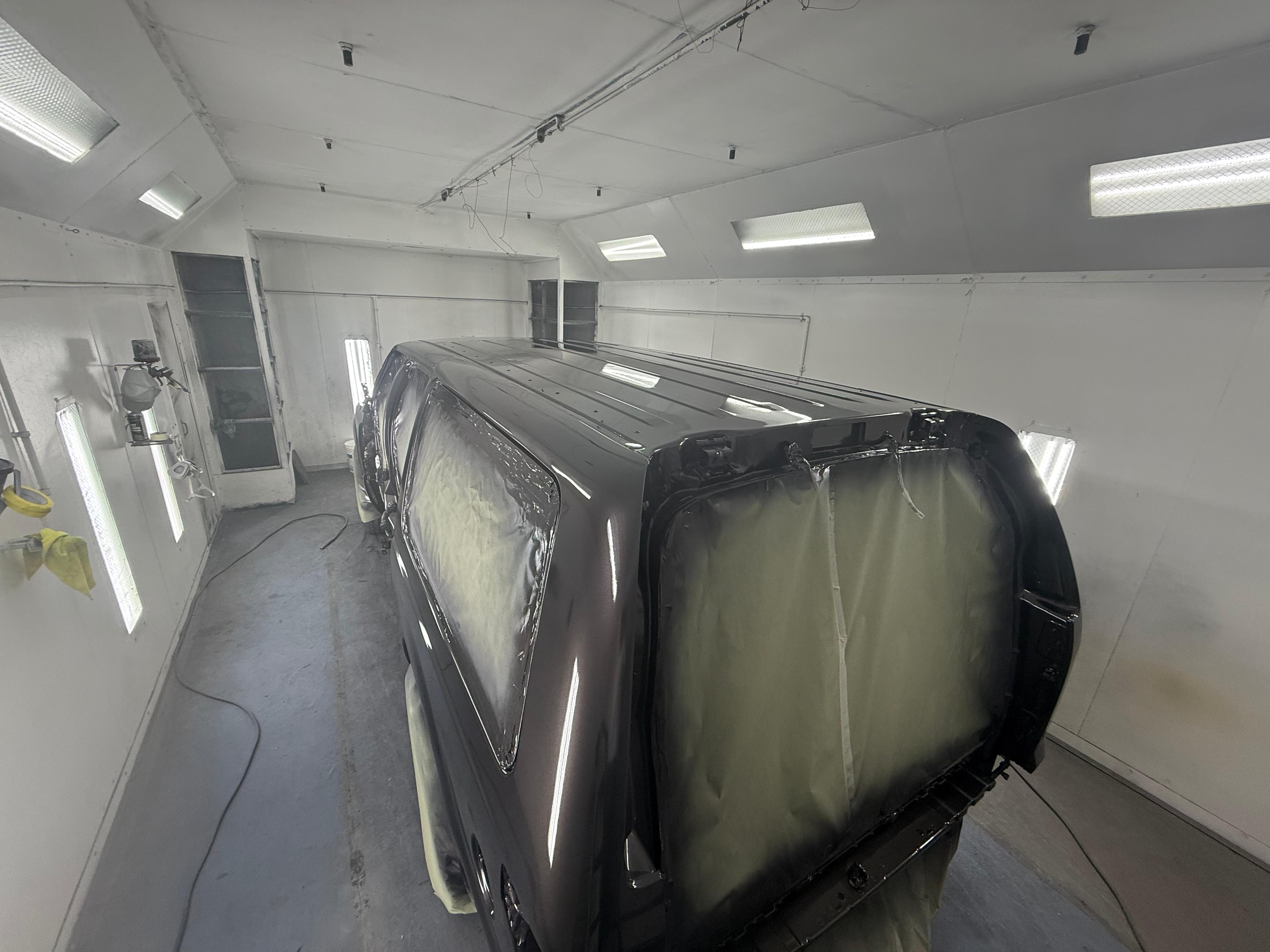 Dark SUV freshly painted in paint booth